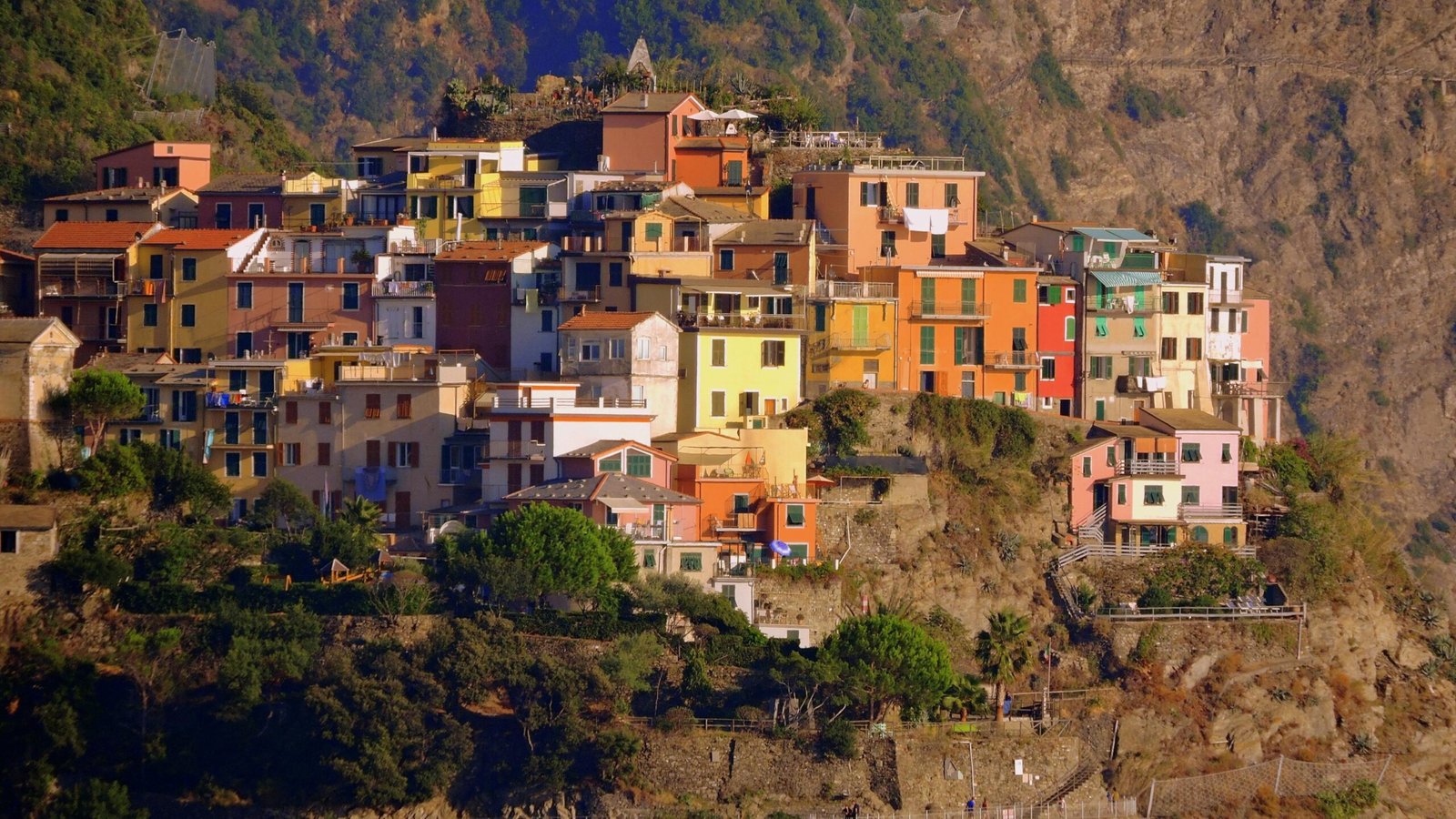 Vibrant, colorful houses perched on a cliff in Corniglia, part of Italy's scenic Cinque Terre region.