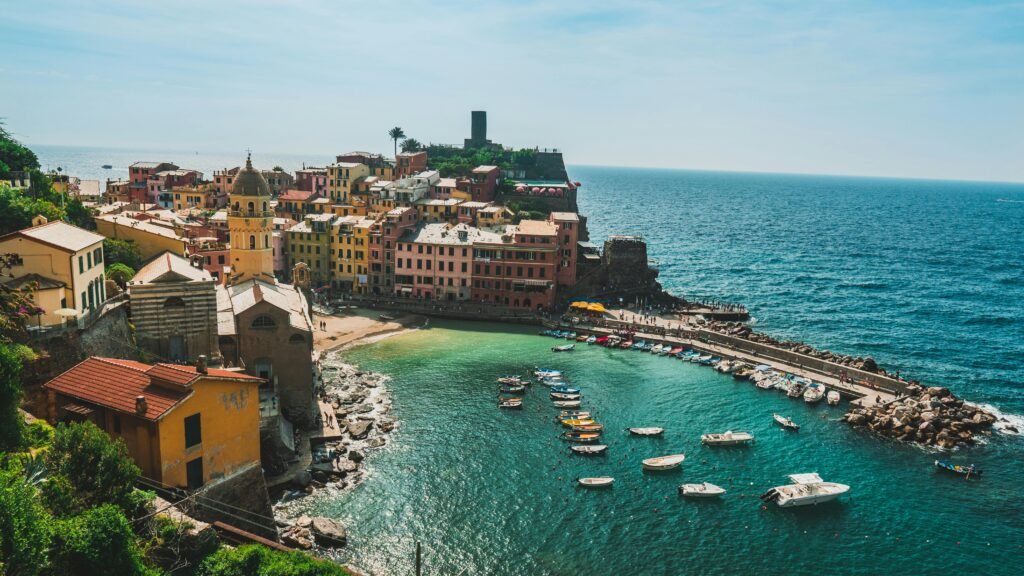 A picturesque aerial view of Vernazza's colorful buildings and harbor along the Italian coastline.