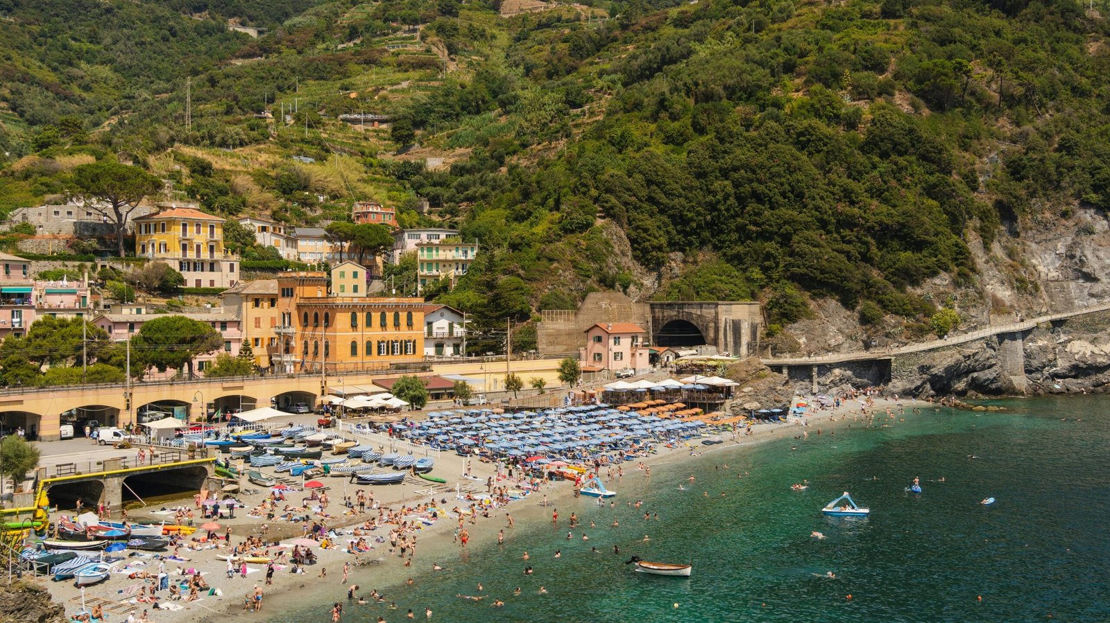 A vibrant beach scene in Monterosso al Mare, part of Cinque Terre, Italy.